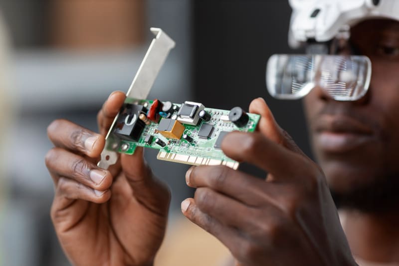 Technology: hands examining a circuit board